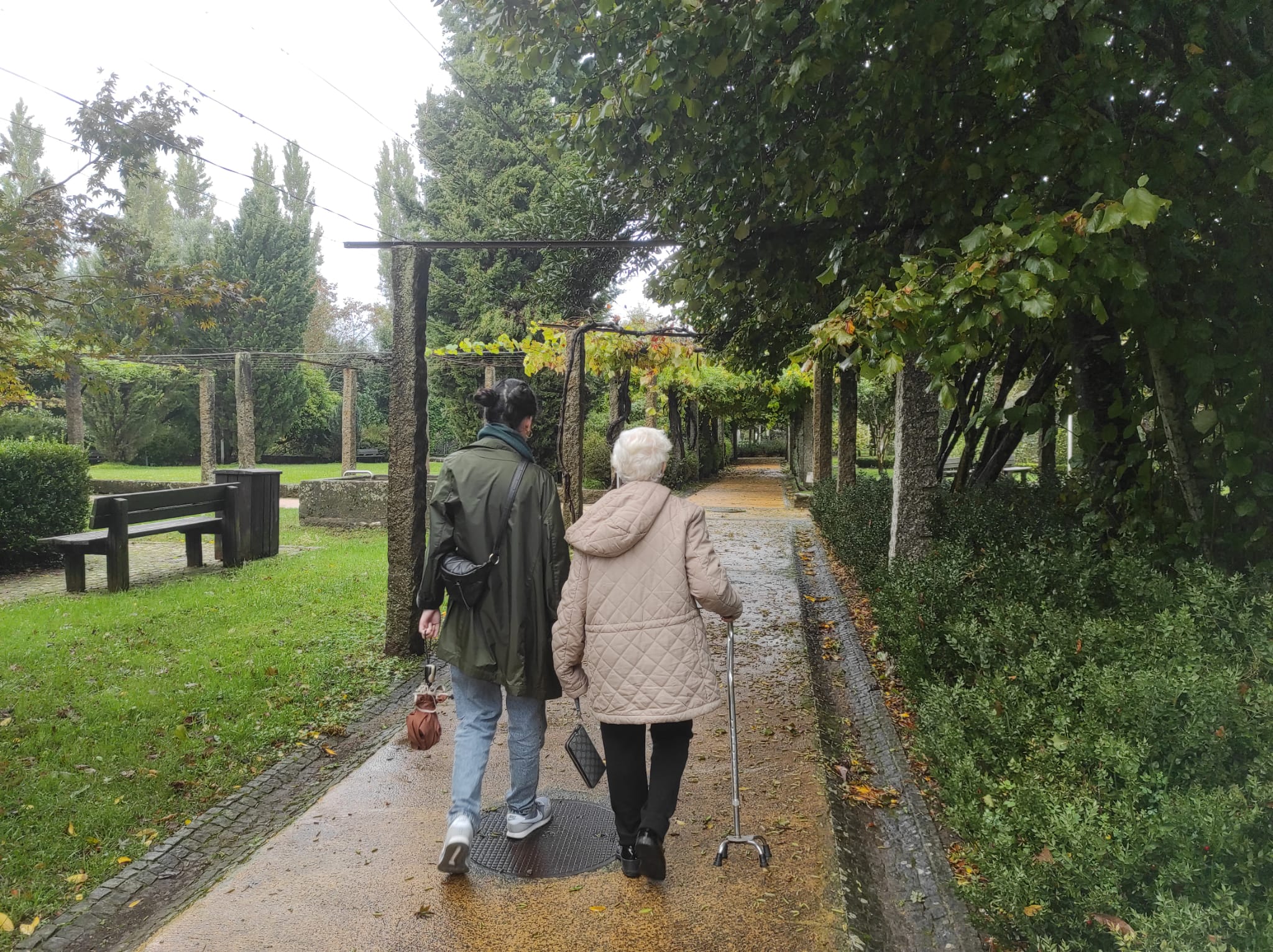 woman walking with her grandma in a garden on a rainy day