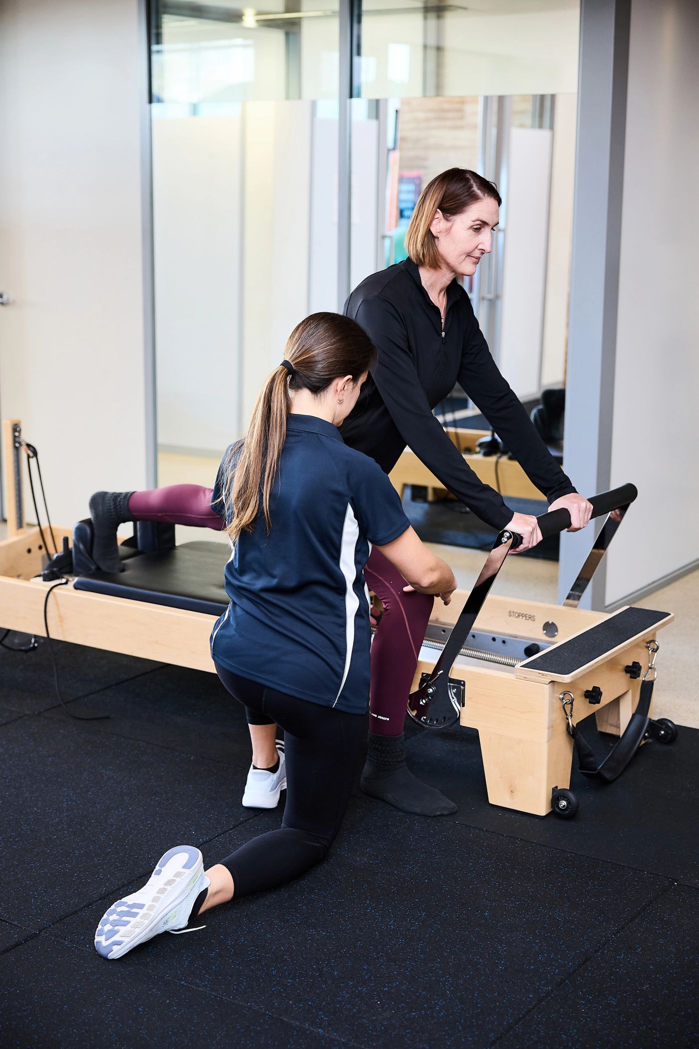 Physiotherapist guiding a client through a Clinical Pilates exercise on the reformer