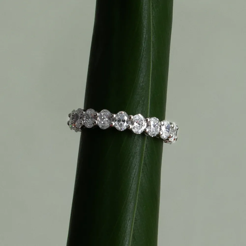 Cullen Jewellery diamond eternity band displayed on a dark green leaf, highlighting the brilliance of the stones against a natural backdrop.