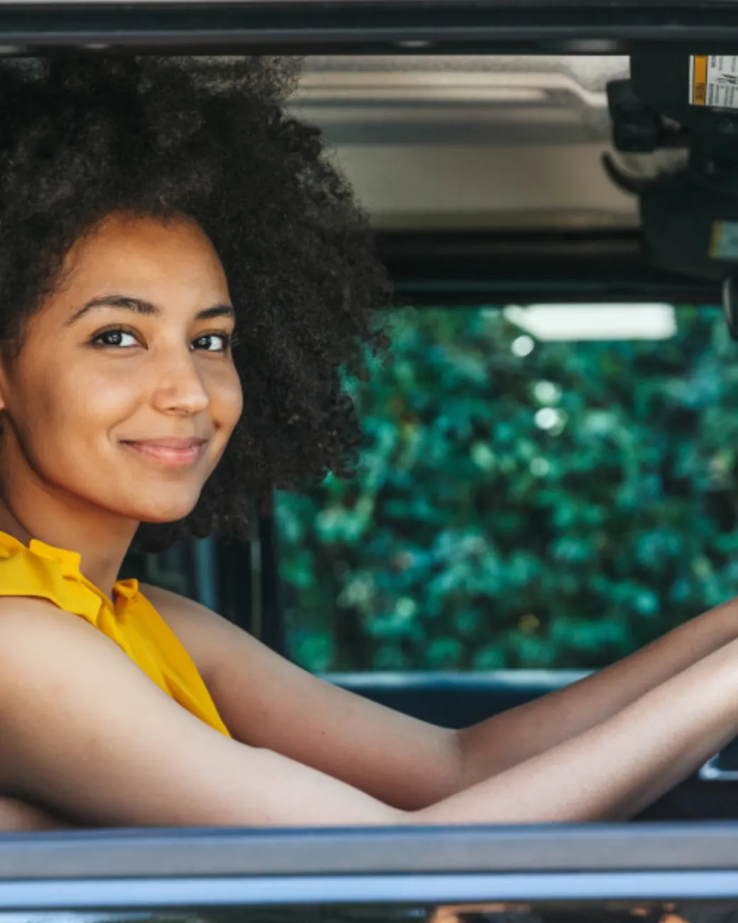 EzLicence learner driver smiling confidently behind the wheel of a car.