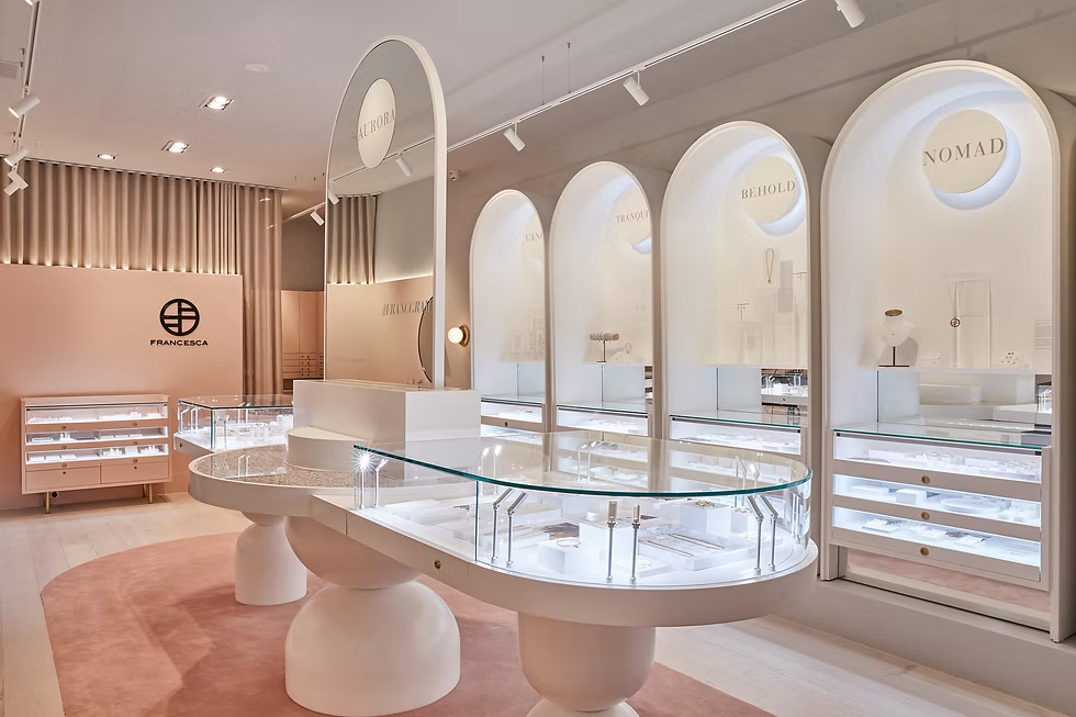 Francesca jewellery boutique interior with modern curved glass displays, soft blush accents and illuminated wall niches showcasing collections like Nomad and Behold