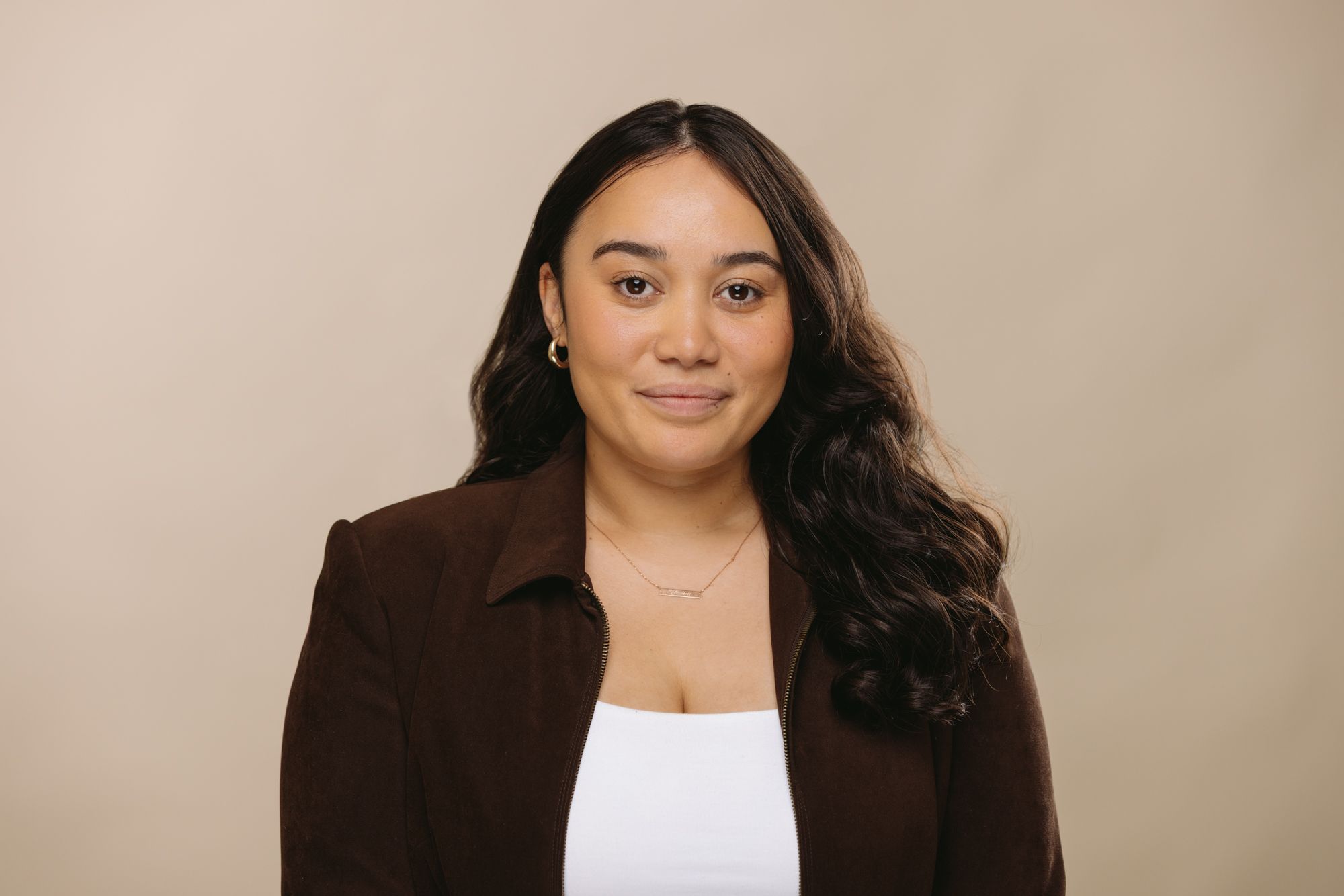 Yhanni Walker Executive Assistant at House of Psalm professional headshot wearing black top and dark brown blazer