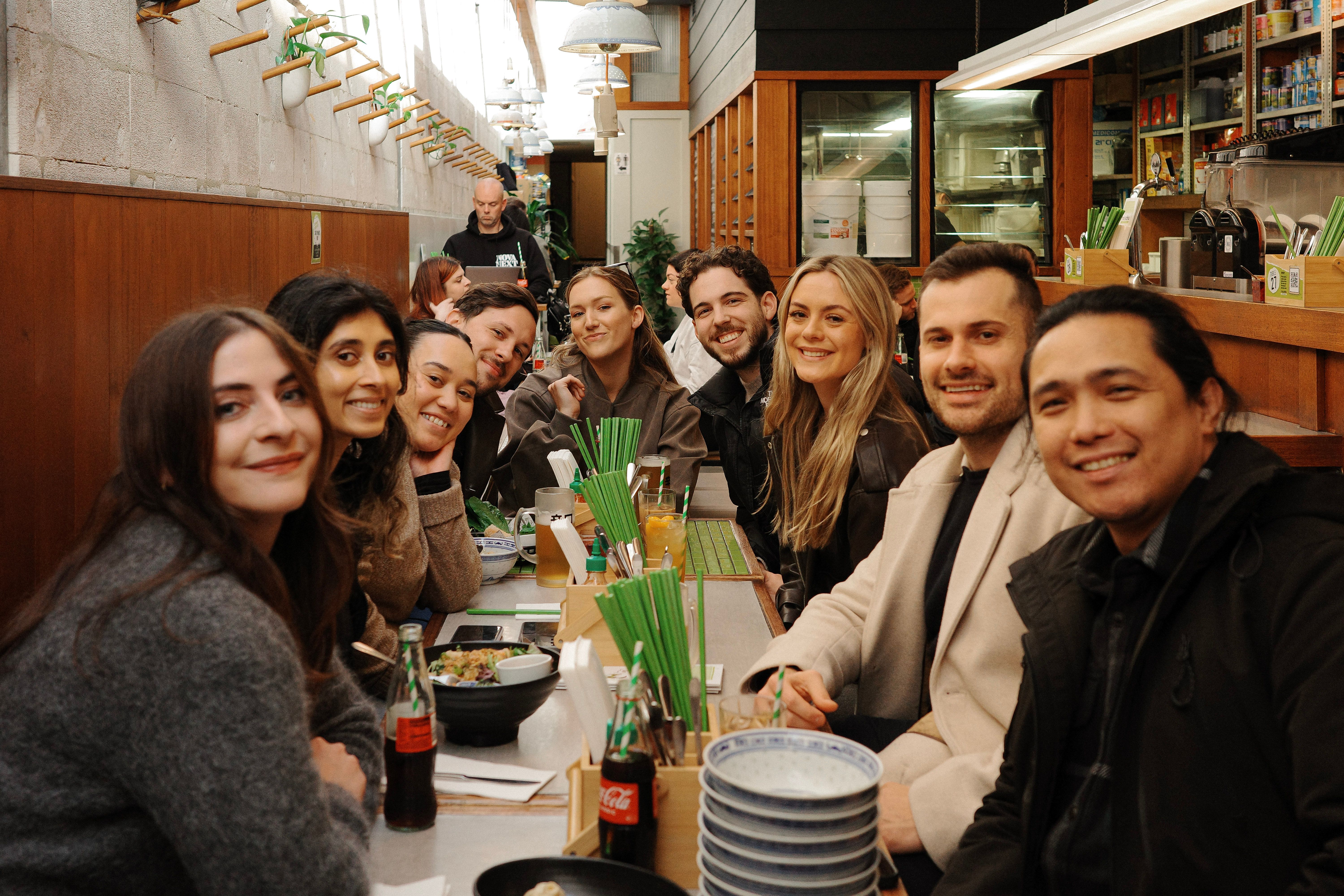 House of Psalm team group lunch at restaurant with bowls, drinks, and long dining table