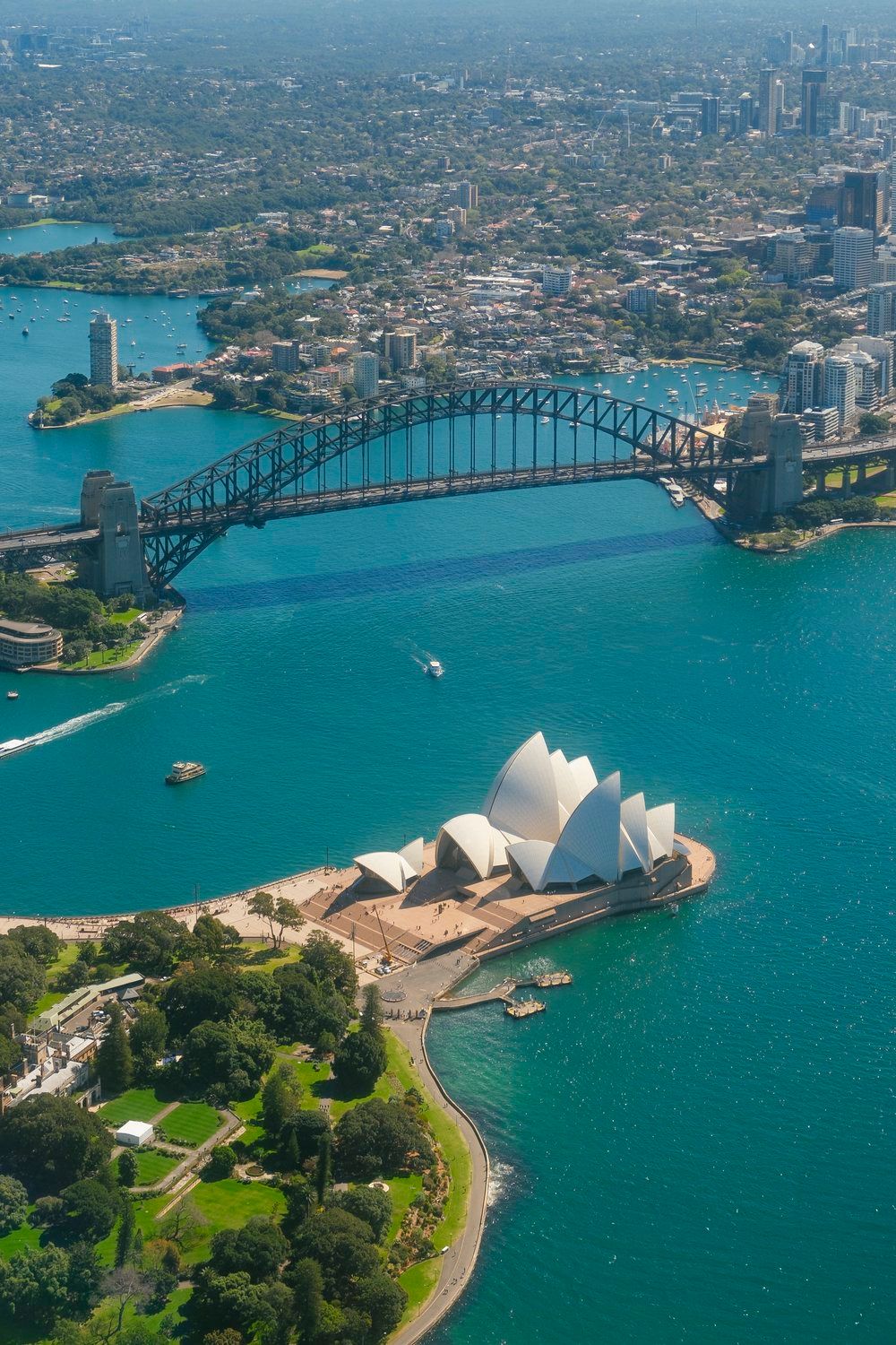 Aerial view of Australian Harbour Bridge & Sydney Opera House and turquoise ocean waters