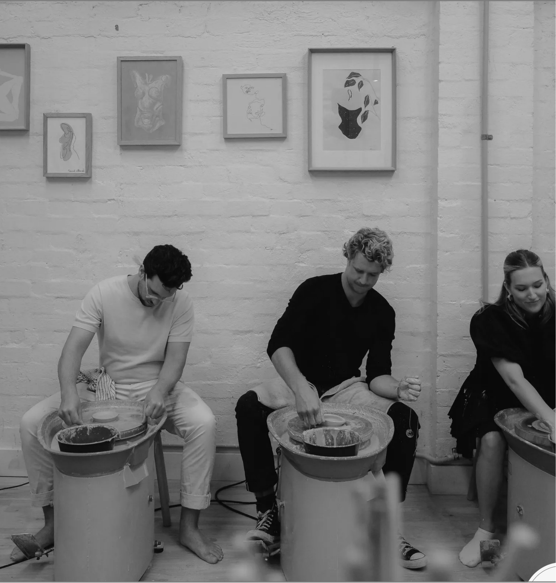 House of Psalm team pottery class with members seated at wheels creating ceramics