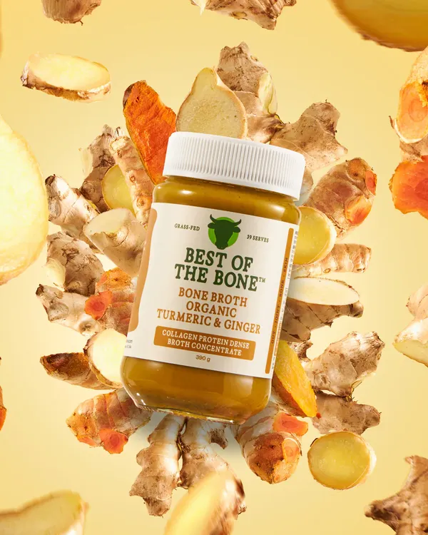 Best of the Bone organic bone broth concentrate with turmeric and ginger surrounded by fresh root ingredients