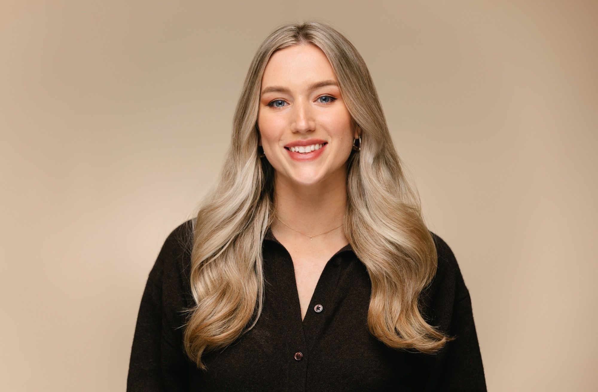 Tara King Stanley Creative Director of House of Psalm professional headshot wearing brown cardigan with beige trousers