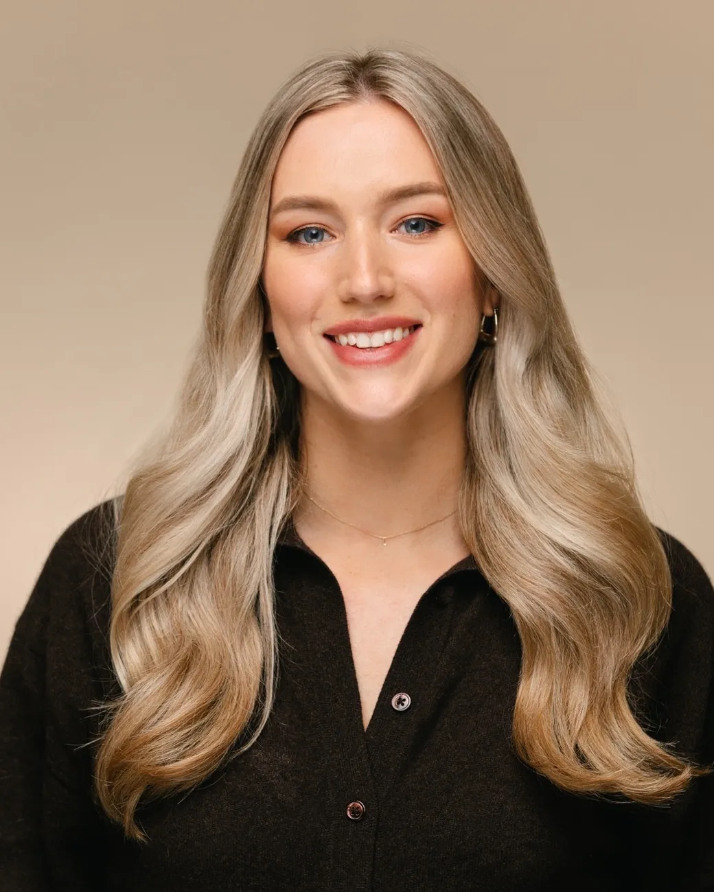 Tara King Stanley Creative Director of House of Psalm professional headshot wearing brown cardigan with beige trousers
