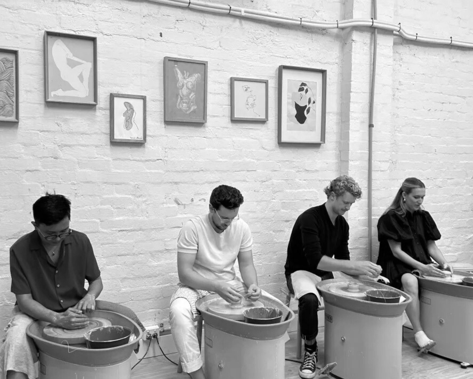 House of Psalm team pottery class with members seated at wheels creating ceramics
