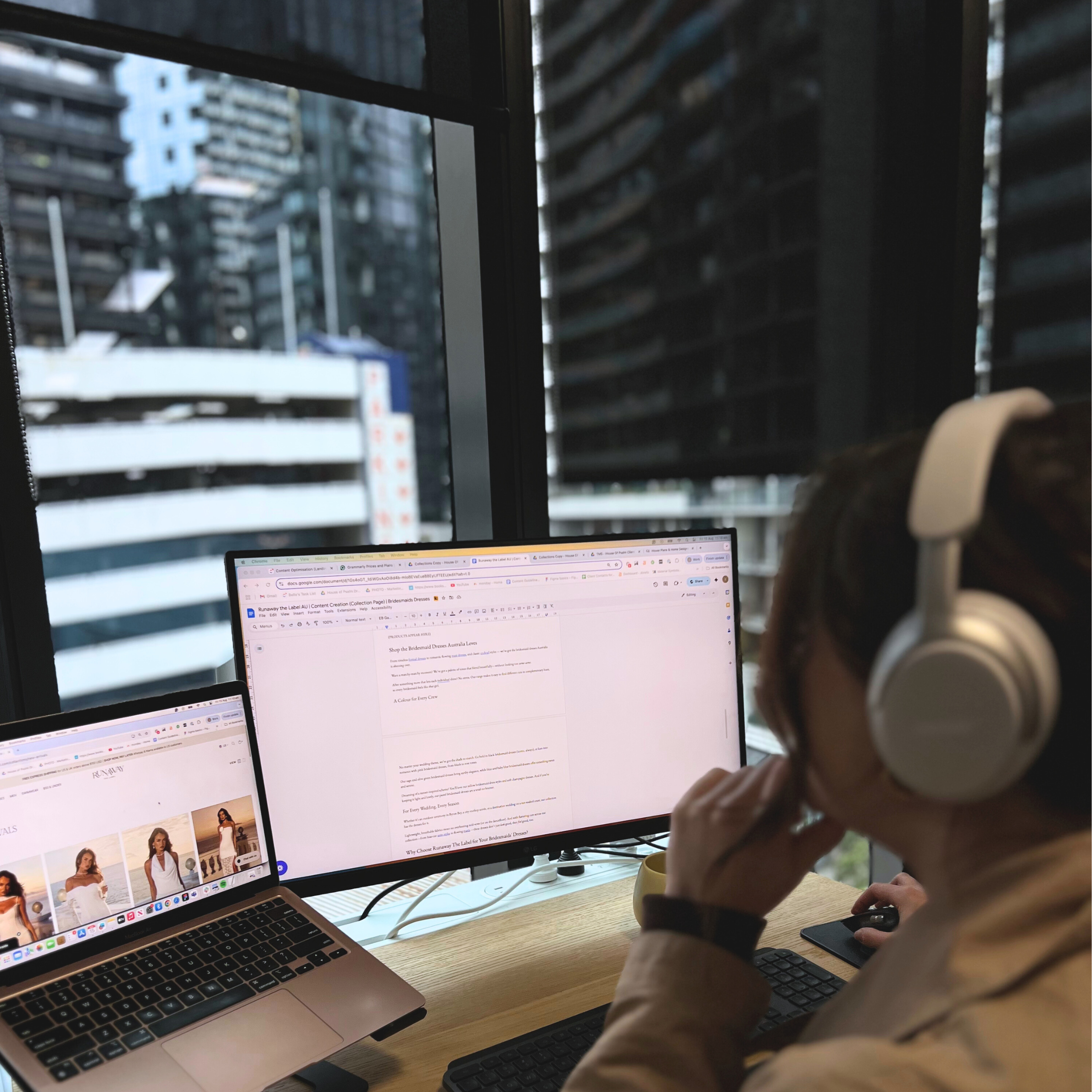 House of Psalm digital PR specialist wearing headphones working on media outreach documents and campaign strategy at dual monitors in office