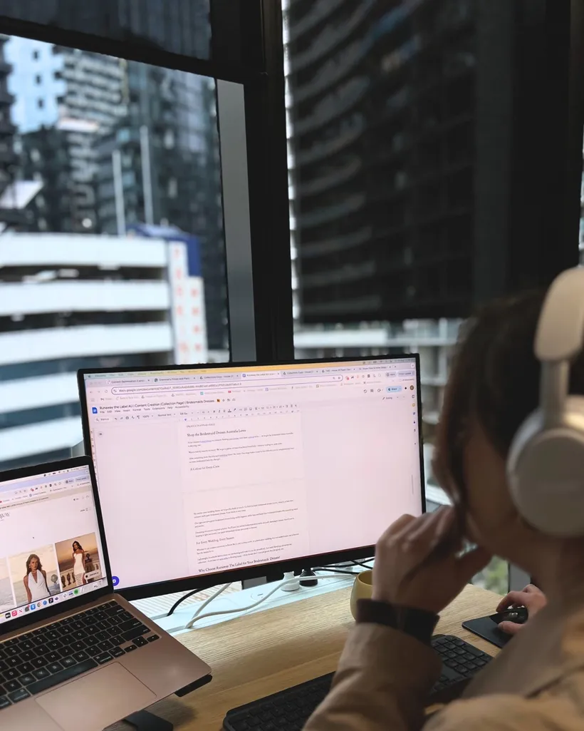 House of Psalm digital PR specialist wearing headphones working on media outreach documents and campaign strategy at dual monitors in office