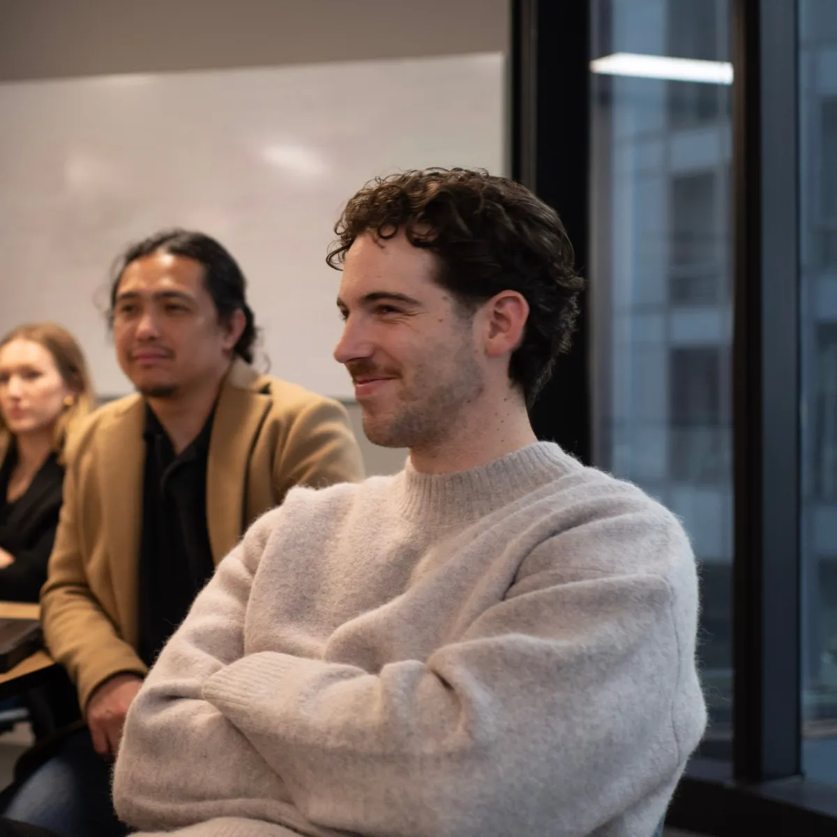 House of Psalm team members in a meeting, engaged in discussion around the table with a modern office backdrop