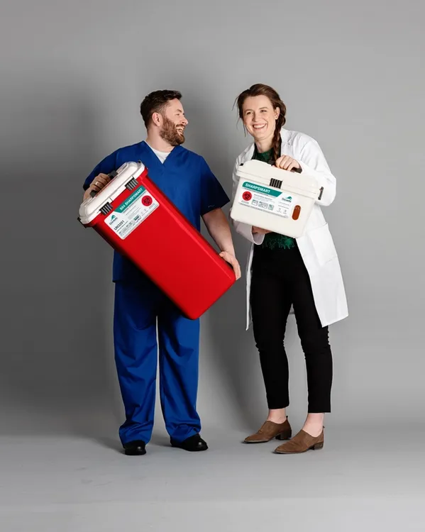Daniels Health medical staff holding reusable sharps containers for safe biomedical waste disposal in clinical setting