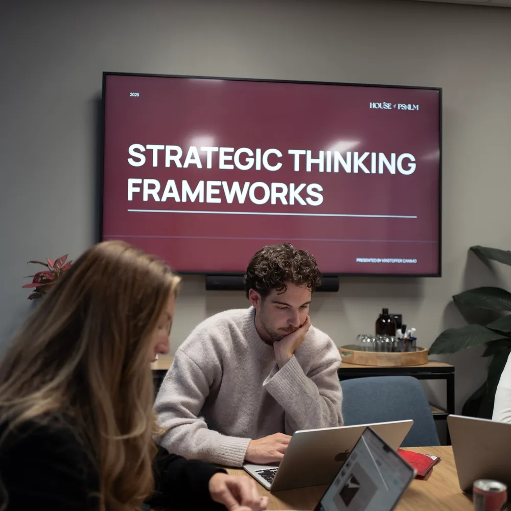 House of Psalm team workshop on strategic thinking frameworks with laptops in office meeting room