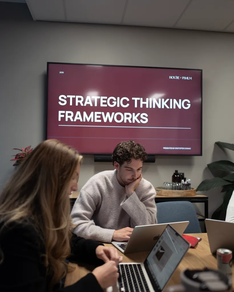 House of Psalm team in strategy workshop with laptops discussing Strategic Thinking Frameworks presentation in office