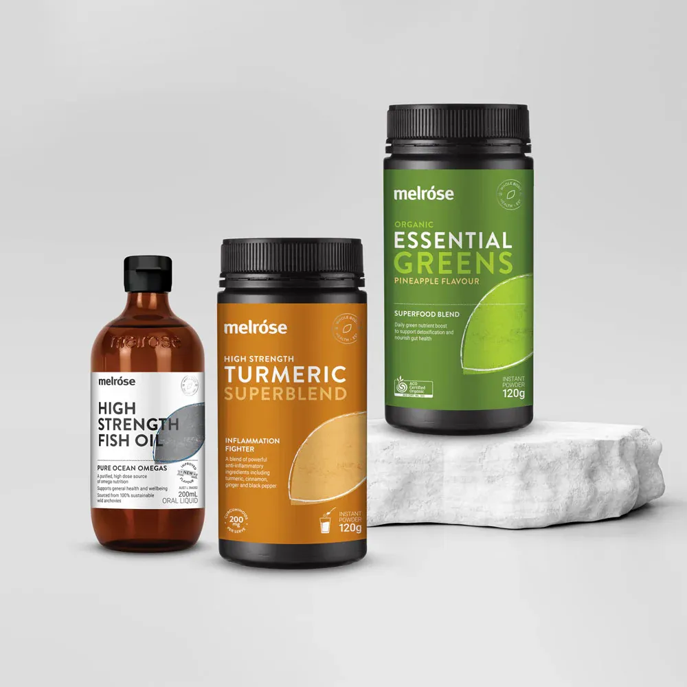 Melrose supplements including High Strength Fish Oil, Turmeric Superblend, and Essential Greens, displayed on a stone block against a grey background.