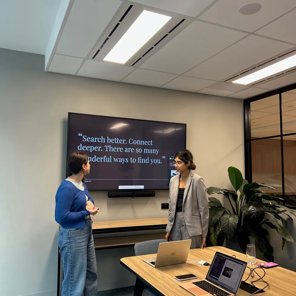 House of Psalm team presenting a PR and SEO strategy in a modern office meeting room, with a screen showing the quote “Search better. Connect deeper. There are so many wonderful ways to find you.”