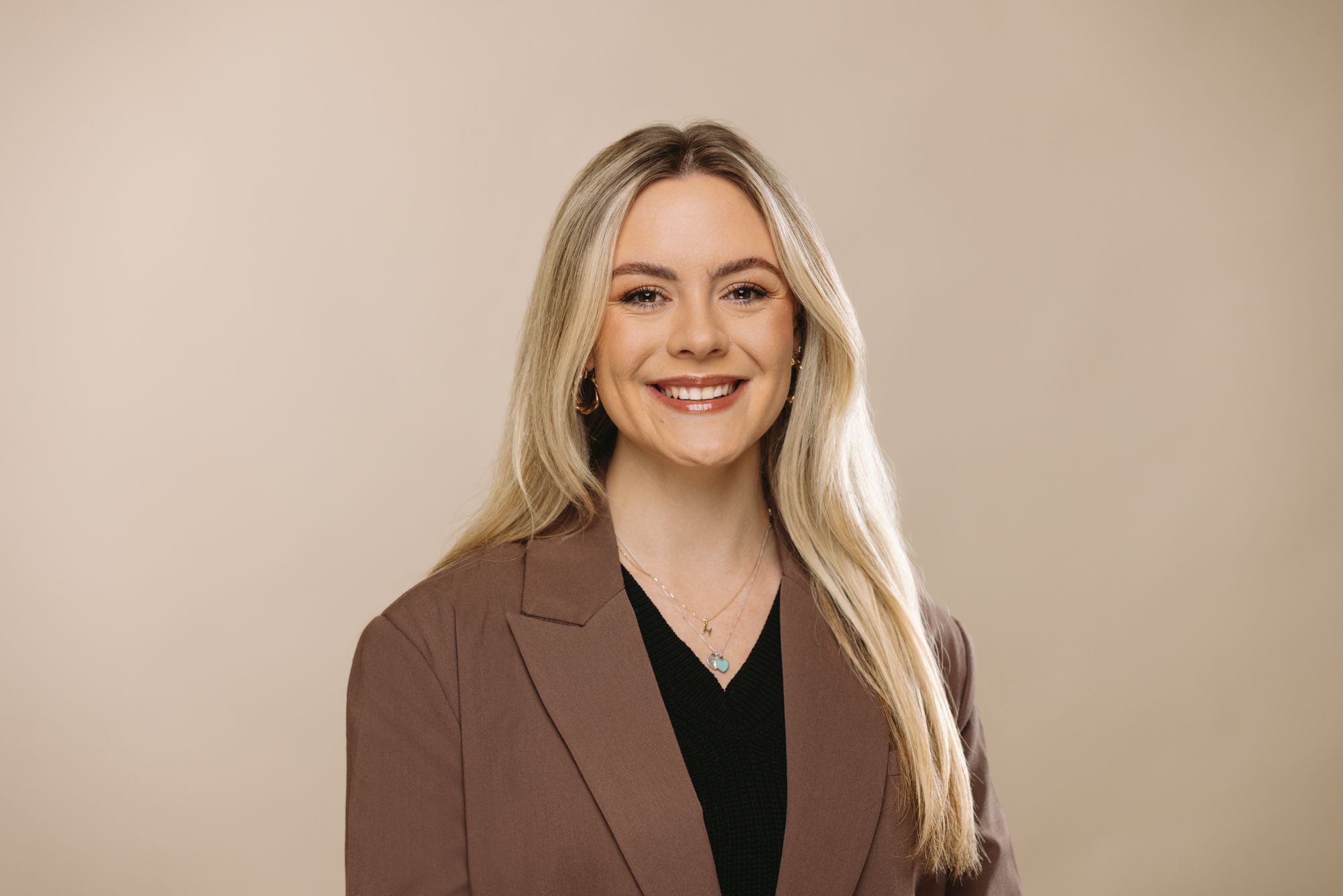 Alicia Faulkner Digital PR Manager at House of Psalm professional headshot wearing black top with beige jacket