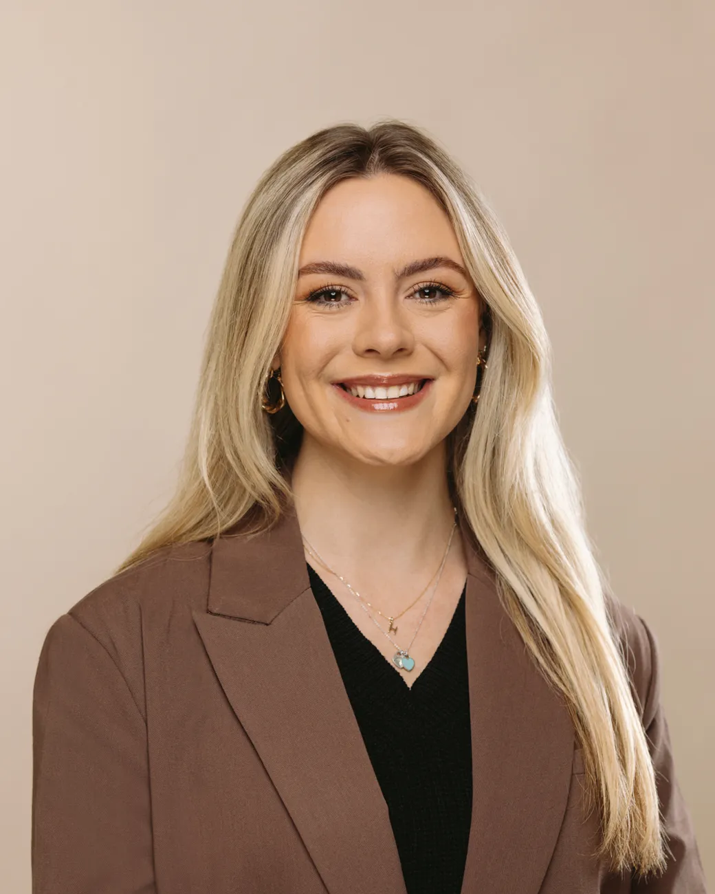 Alicia Faulkner Digital PR Manager at House of Psalm professional headshot wearing black top with beige jacket