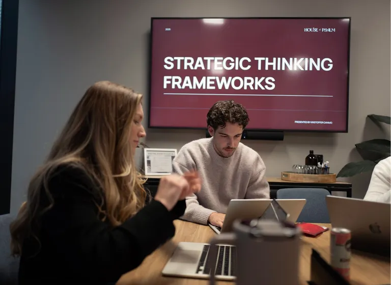 House of Psalm team in strategy meeting with presentation screen on brand performance
