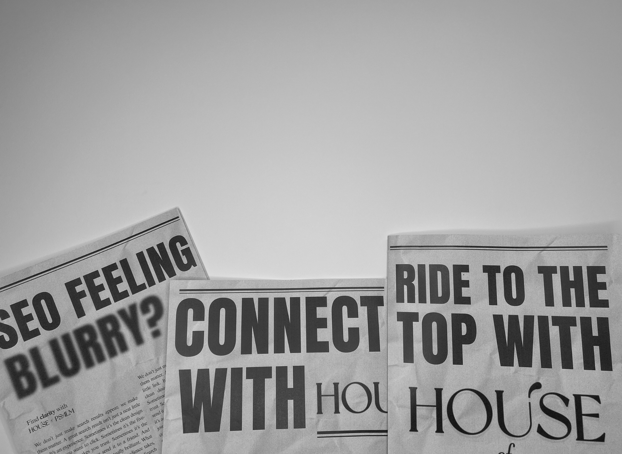 Black and white newspapers with bold headlines reading “SEO feeling blurry?”, “Connect with House of Psalm,” and “Ride to the top with House of Psalm,” promoting the creative SEO agency.