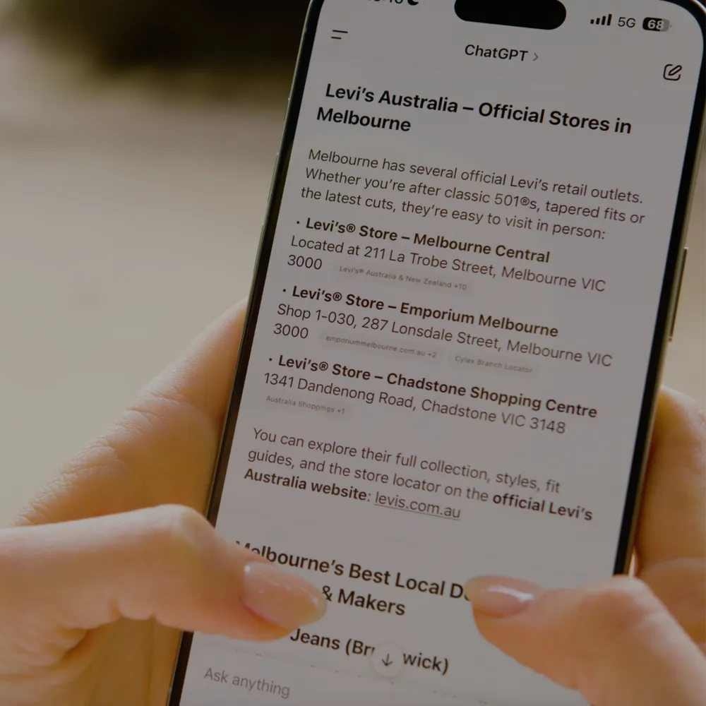 Hand holding a smartphone showing Levi’s Australia official stores in Melbourne, including Melbourne Central, Emporium Melbourne, and Chadstone Shopping Centre.