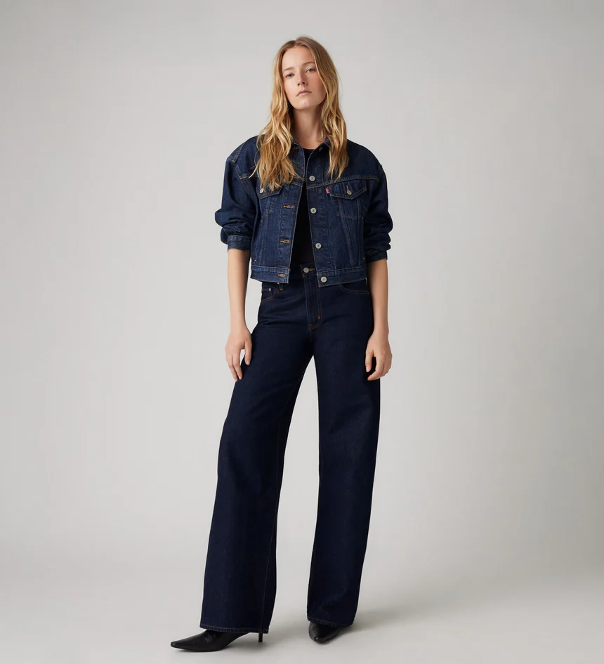 Model wearing classic Levi’s dark denim jacket and wide-leg jeans