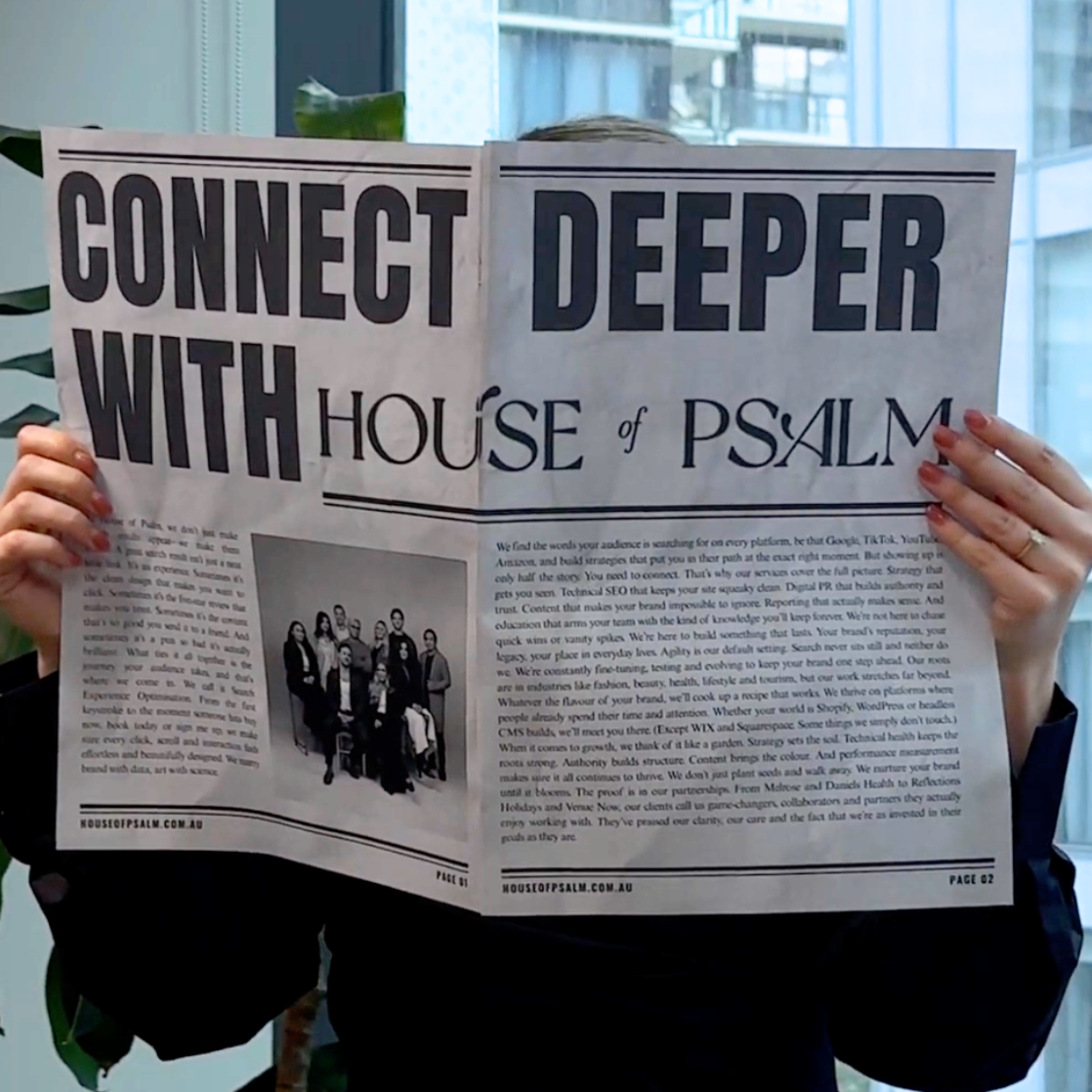 Person holding a newspaper with the headline “Connect Deeper with House of Psalm,” featuring agency branding and team photo inside.
