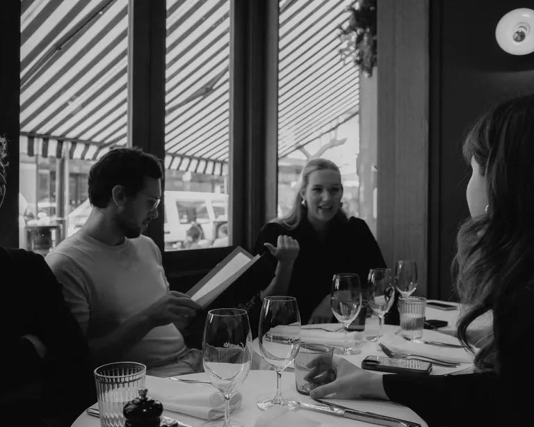 House of Psalm team members having lunch meeting at restaurant table with menus and glasses