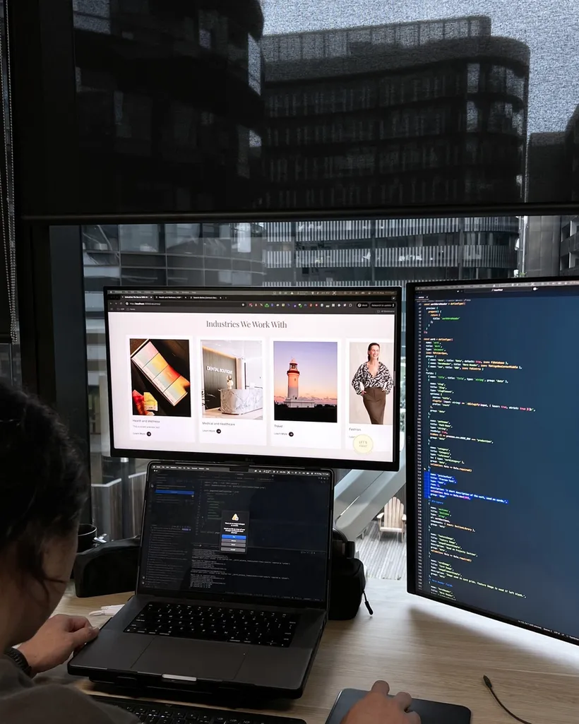 House of Psalm developer working on website code and design across dual monitors showing Reflections Holidays and fashion client pages