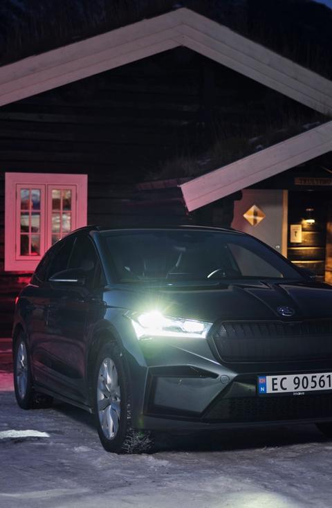 Skoda Enyaq utenfor laftet fjellhytte vinter på natten