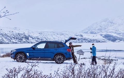Mann BMW ix3, fjell snø