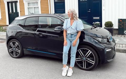 Andrea står forran en  BMW i3 på bilabonnement imove sørlandet sommer
