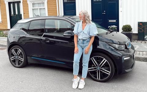 Andrea står forran en BMW i3 på bilabonnement imove sørlandet sommer