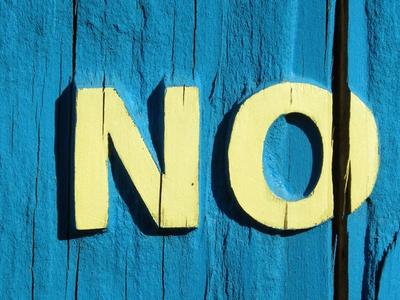 The word "no" on a turquoise and yellow wooden sign.