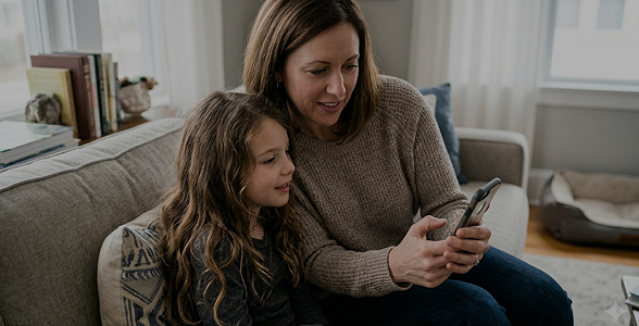 Mom and daughter looking at a smart phone together