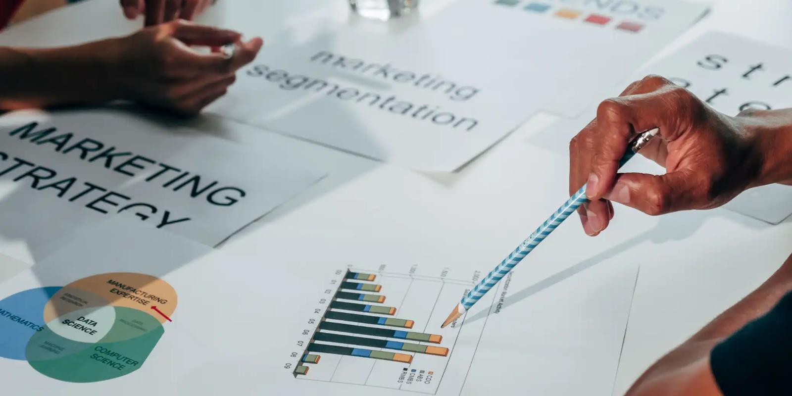 Team reviewing printed charts while planning audiences, messages and offers for an ABM direct mail campaign.