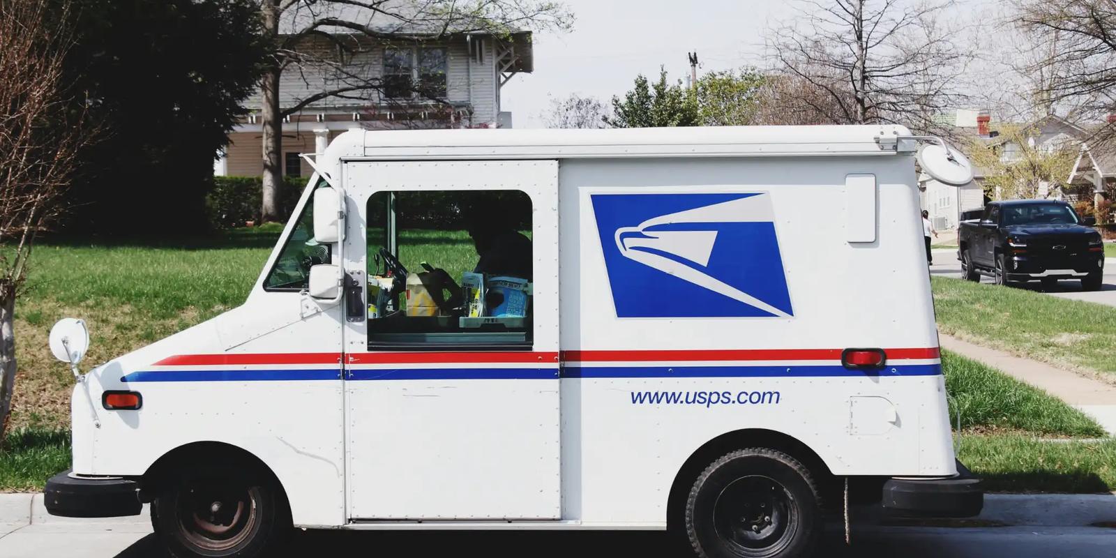 Postal delivery truck on a residential street, illustrating delivery for targeted direct mail and mass mailing.