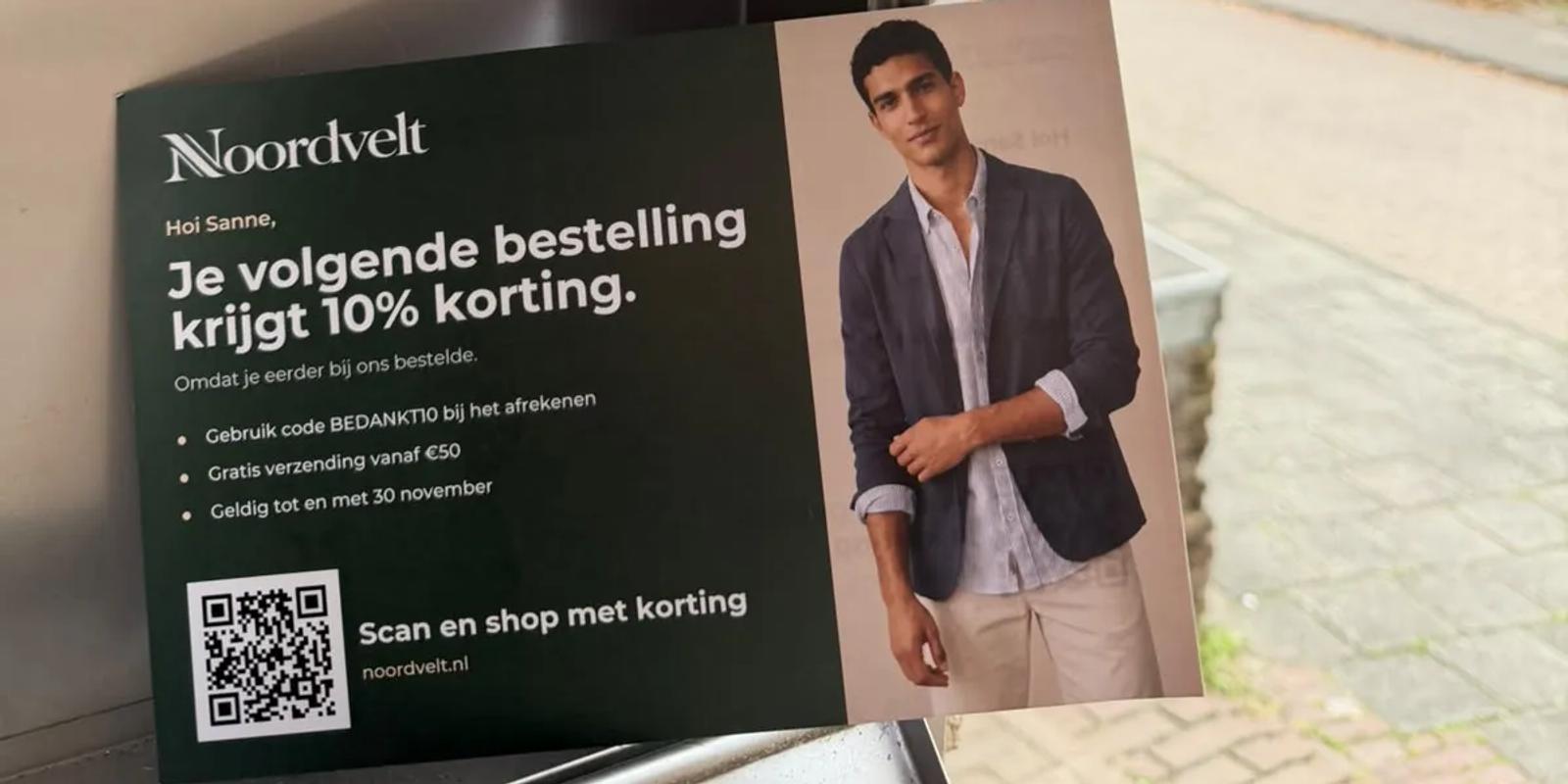 Persoonlijke kaart van een webwinkel met kortingscode en QR-code bij een Nederlandse brievenbus
