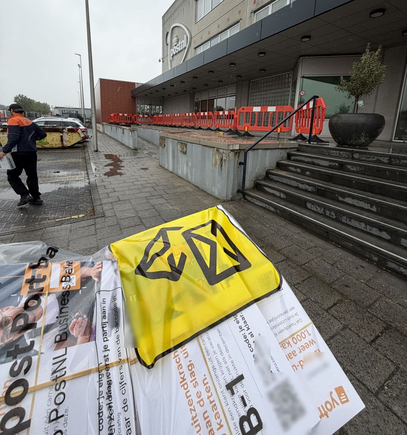 Zakken met Yotru-kaarten op de stoep voor een PostNL-gebouw met de Business Balie