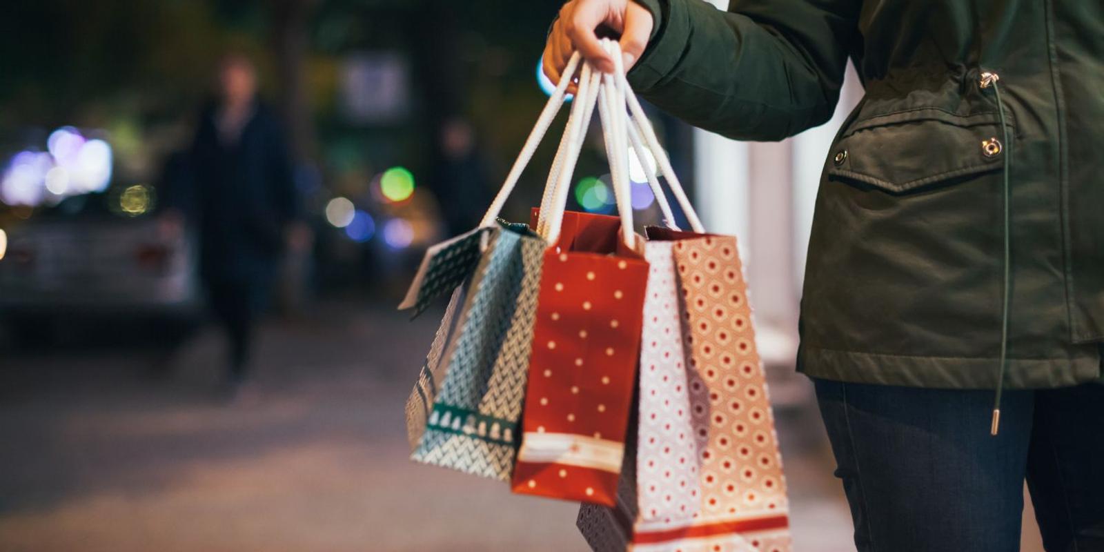 Customer receiving a shopping bag at checkout, illustrating how WooCommerce stores can encourage repeat purchases through personalized postcard marketing.