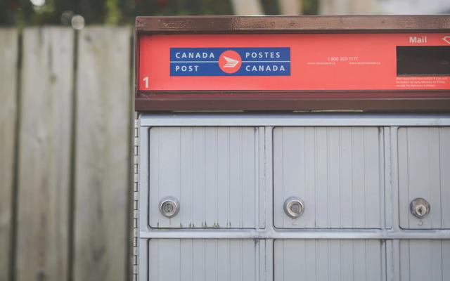 Red Canada Post community mailbox with rows of locked mail compartments