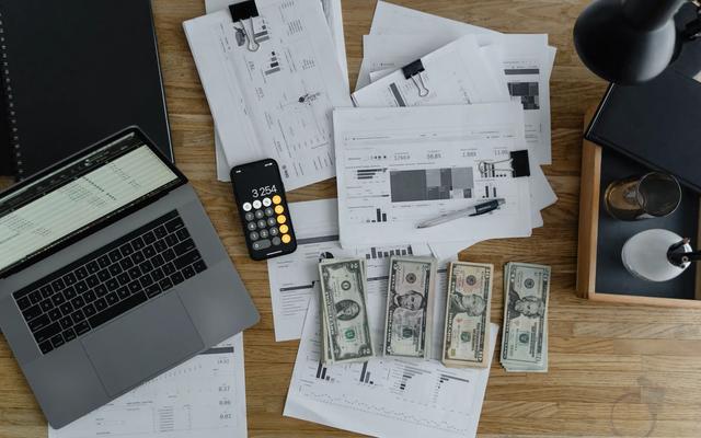 Overhead view of printed materials and a laptop on a desk, illustrating B2B direct mail campaign planning.
