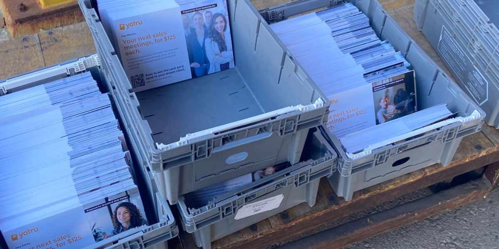 Overhead view of envelopes and stationery on a wooden desk, illustrating materials used in B2B direct mail.