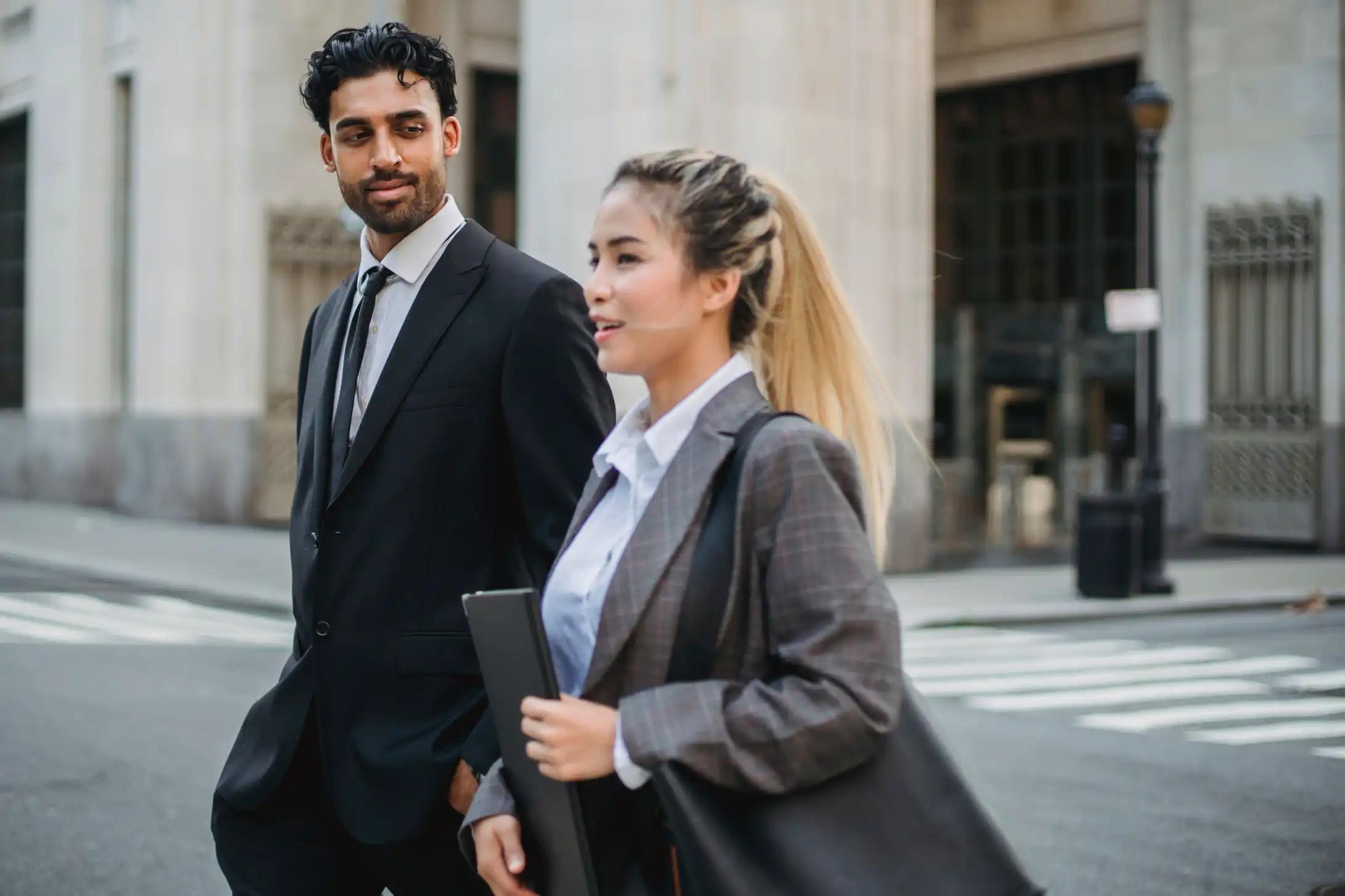 Business professionals outside an office, representing decision-makers targeted by B2B postcard campaigns.