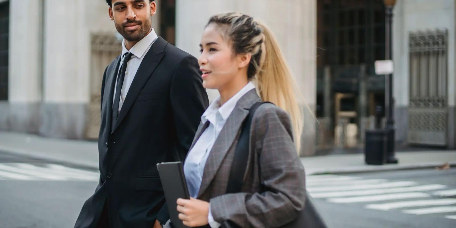 Business professionals outside an office, representing decision-makers targeted by B2B postcard campaigns.