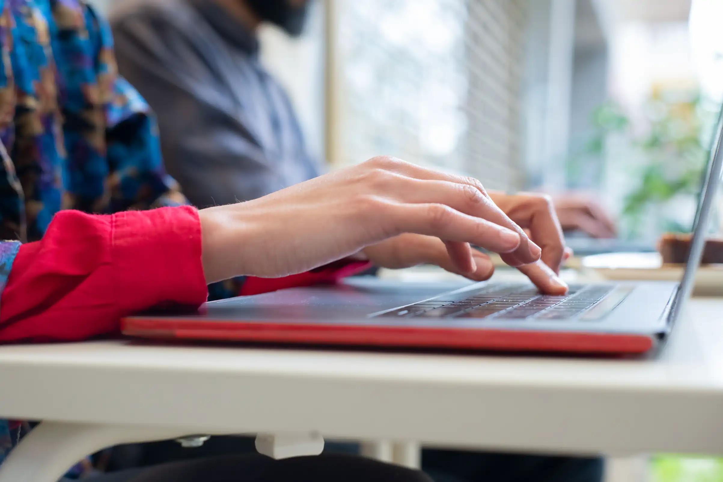 Person typing on a laptop, illustrating follow-up emails in a B2B direct mail sequence.