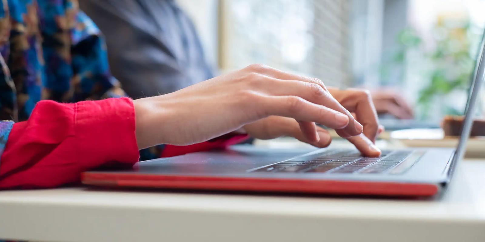 Person typing on a laptop, illustrating follow-up emails in a B2B direct mail sequence.