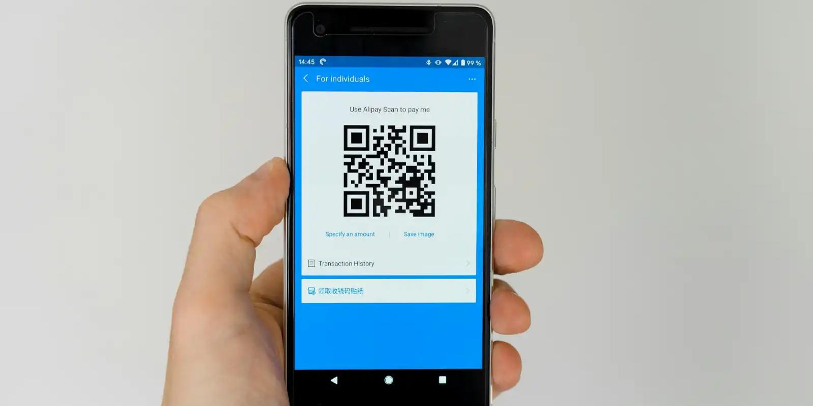 Hand holding a smartphone displaying a QR code, illustrating QR codes used in direct mail campaigns.