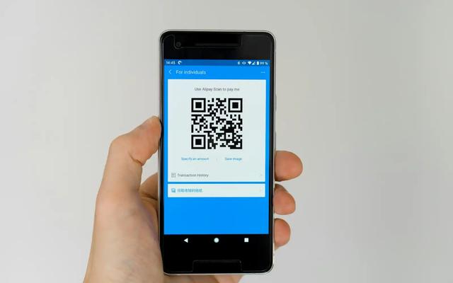 Hand holding a smartphone displaying a QR code, illustrating QR codes used in direct mail campaigns.